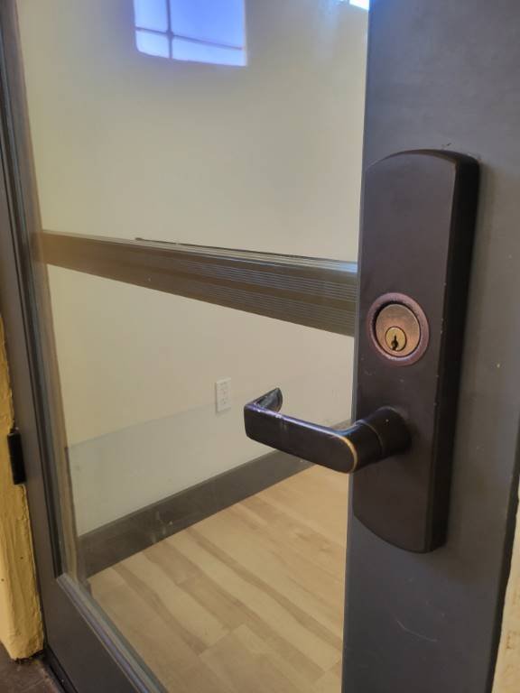Commercial glass door with a bronze mortise lock cylinder serviced by Locks Around the Clock in El Paseo