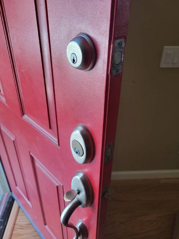 Red front door fitted with multiple high-security deadbolts after a Palm Desert residential upgrade