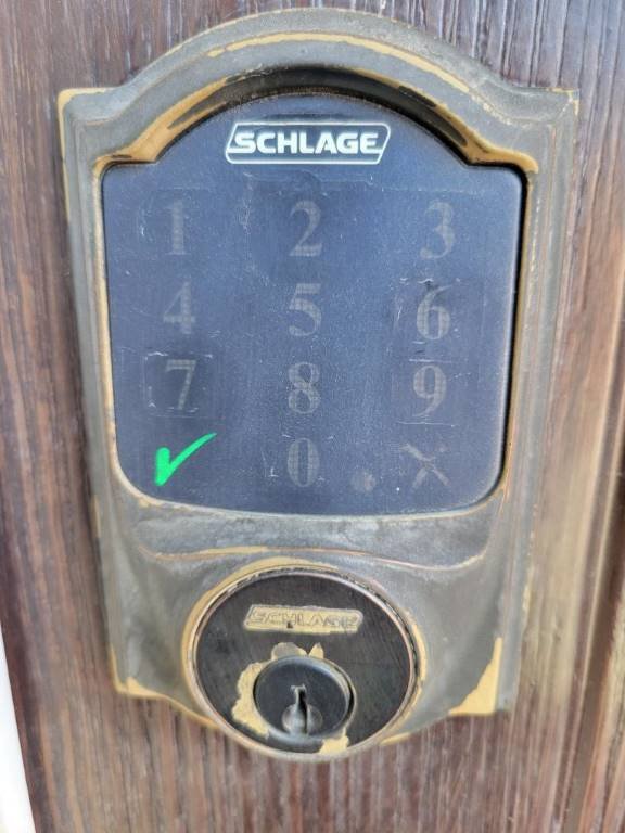 Schlage smart keypad deadbolt being serviced on a residential wood door in Indian Wells